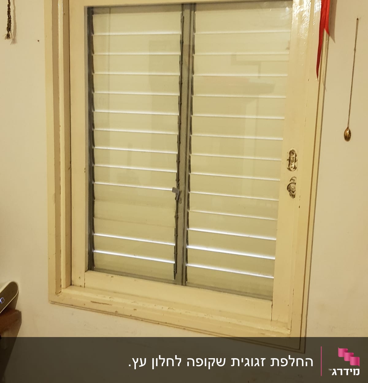 חלון עם תריסים סגורים במסגרת עץ